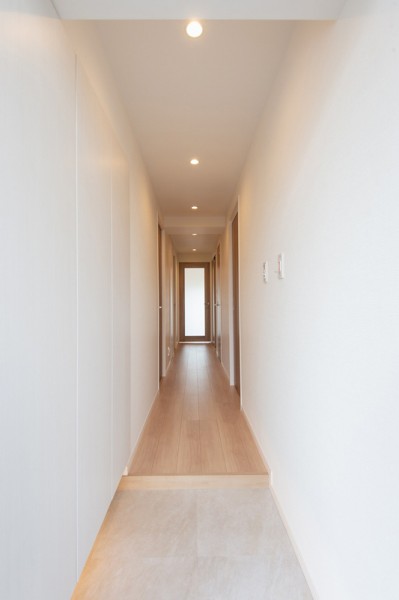 玄関から真っすぐ伸びた廊下。建具はナチュラルな色味と風合いでお部屋全体が居心地の良い空間となります。