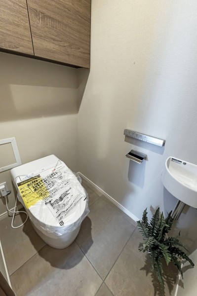 手洗い場付きのタンスレストイレを新規設置しました。収納に便利な吊戸棚も備え付けで実用的です。