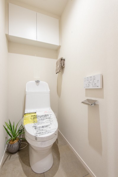 お掃除の手間が省ける便利機能搭載のTOTO製トイレに新規交換しました。上部の吊戸棚にはトイレ周りのものを収納できて便利です。