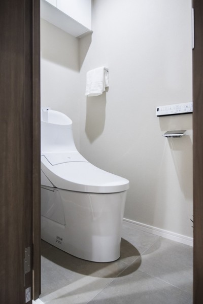 お掃除の手間を減らしてくれる機能が充実したトイレです。トイレットペーパーや掃除用具なども収納できる実用的な吊戸棚が便利です。