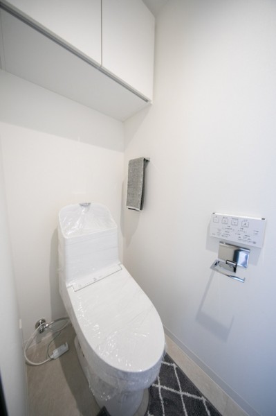 TOTO製洗浄便座付トイレを新規交換。トイレットペーパーなどの収納に便利な吊戸棚も備え付けられております。