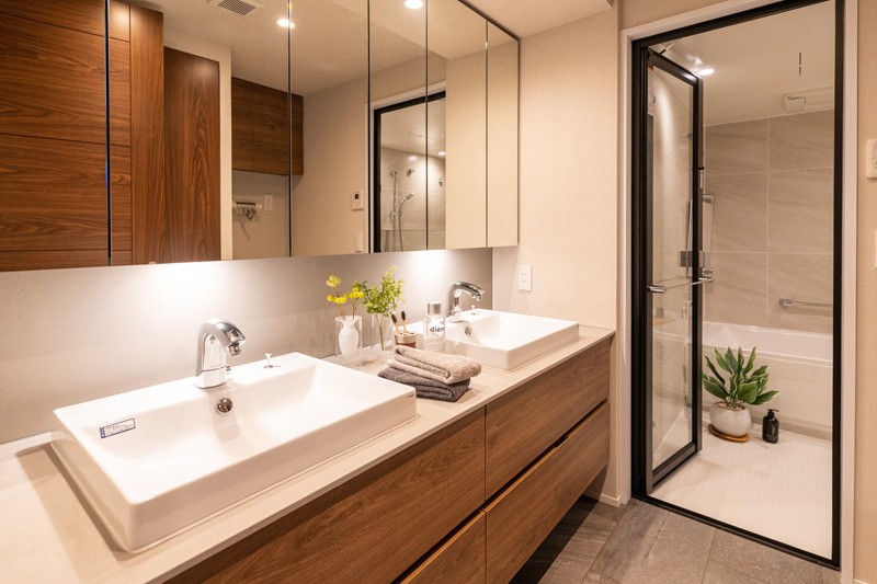 奥行きのある洗面室には2つの洗面台スペースが設けられております。それぞれに三面鏡が付いており、身支度や収納に便利です。