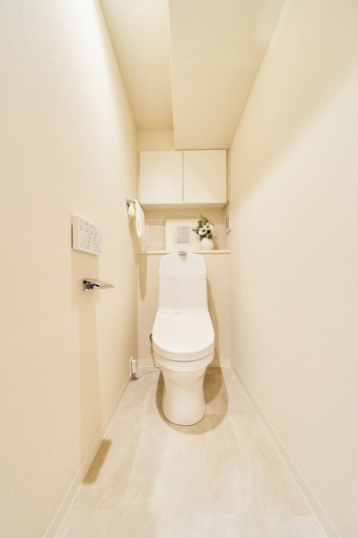 お掃除の手間を減らしてくれる機能が充実したトイレです。トイレットペーパーやお掃除グッズなども収納できる実用的な吊戸棚が便利です。