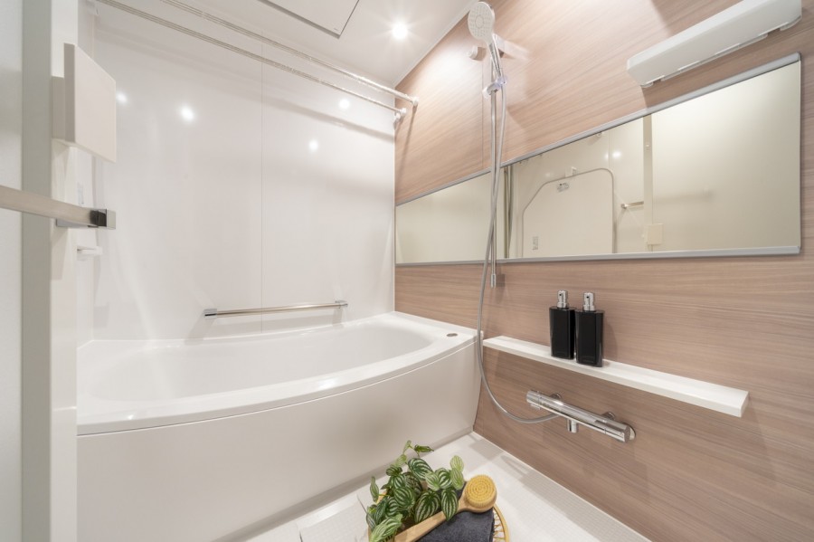 木目調のアクセントパネルがくつろぎの空間を演出するバスルーム。浴室換気乾燥機や追焚機能付きで1年中快適にバスタイムをお楽しみ頂けます。