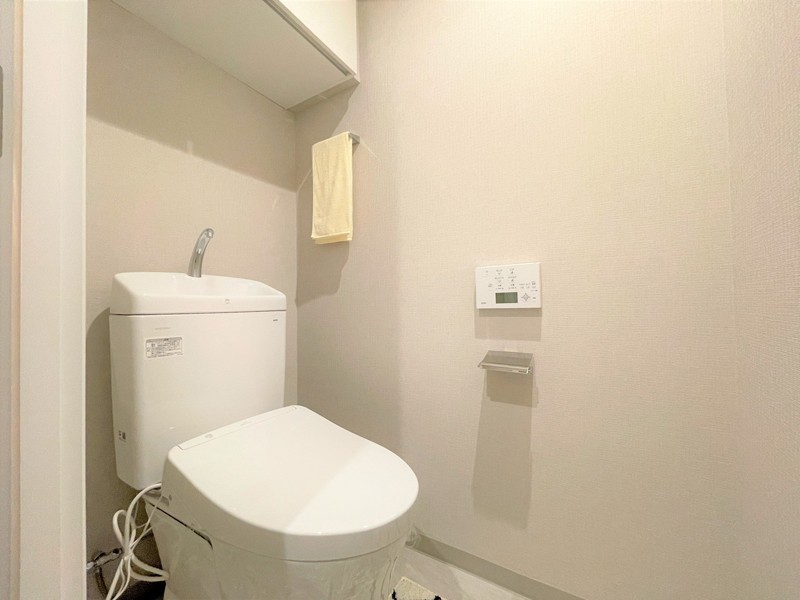 TOTO製洗浄便座付トイレを新規交換。トイレットペーパーなどの収納に便利な吊戸棚も備え付けです。