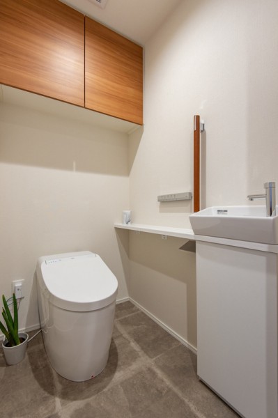 上質なお部屋にぴったりのスタイリッシュなタンクレストイレです。手洗いカウンターや収納に便利な吊戸棚も備え付けです。