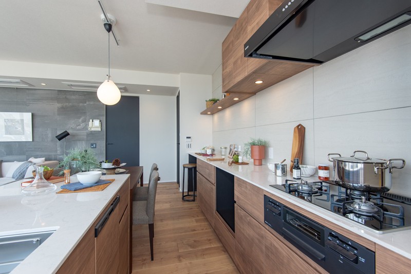 使い勝手の良い二列型キッチンは田中工藝製オリジナルシステムキッチン。薄いホワイトの天板が美しく、暮らしを彩り豊かにしてくれる空間です。