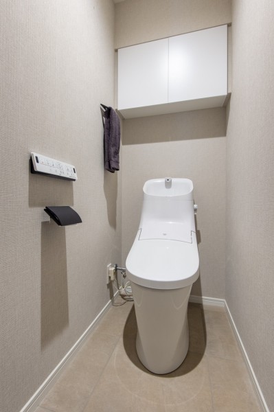 お掃除の手間を減らしてくれる機能が充実したトイレです。上部には収納に便利な吊戸棚を備え付けました。