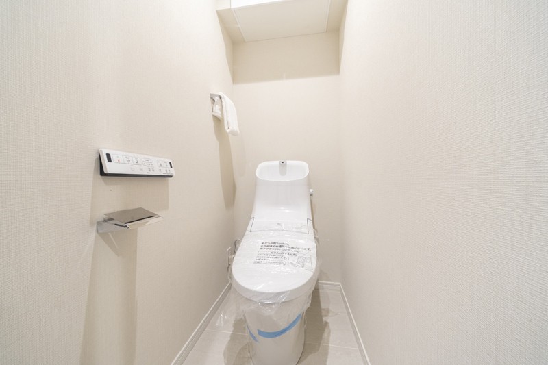 TOTO製洗浄便座付きトイレです。上部には収納に便利な吊戸棚を備え付けました。