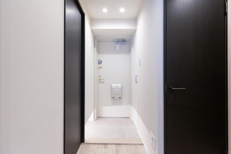 白を基調とした清潔感のある玄関。玄関を入って右手にはシューズボックス、左手には棚を設置しており収納スペースが豊富です。
