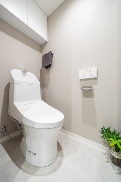 お掃除の手間を減らしてくれる機能が充実したトイレです。備え付けの吊戸棚は、トイレットペーパーや掃除用具などが収納できて便利です。