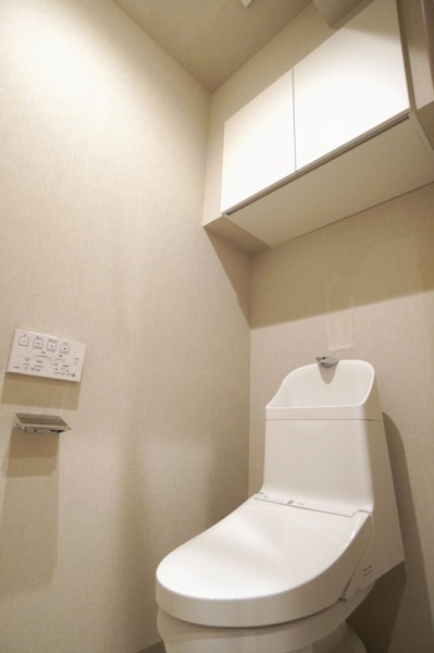 TOTO製洗浄便座付トイレを各階に新規設置。トイレットペーパーなどの収納に便利な吊戸棚も備え付けです。（写真は2階トイレ）