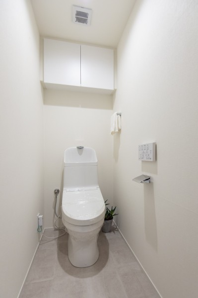TOTO製洗浄便座付トイレを新規設置しました。上部には吊戸棚収納を備えたすっきりとした空間です。