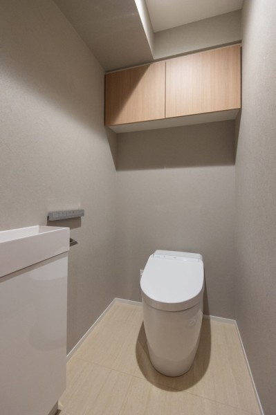 スタイリッシュなタンクレストイレを採用したレストルームです。上部吊戸棚を備えており、空間をすっきりとお使いいただけます。