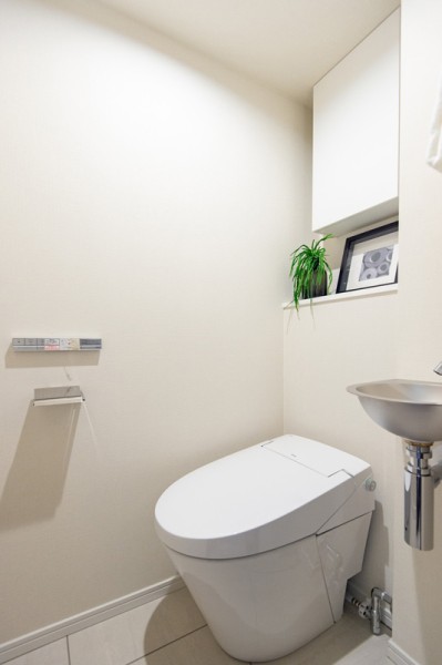 洗練されたお部屋にぴったりなスタイリッシュなタンクレストイレを新規設置しました。手洗い場や収納に便利な吊戸棚も備え付けです。