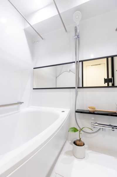 清潔感のあるバスルーム。横長のミラーは洗い場でもバスタブ内でも使え便利なうえ、浴室を広く見せる効果もあります。