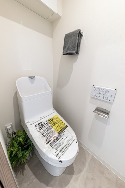 お掃除の手間を減らしてくれる機能が充実したトイレです。トイレットペーパーや掃除用品なども収納できる実用的な吊戸棚が便利です。