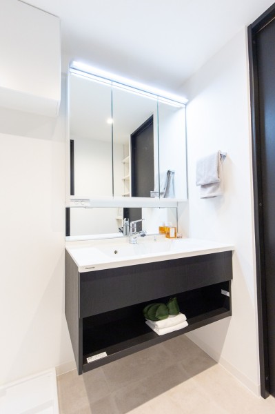 空間に美しく溶け込むスタイリッシュなデザインの洗面化粧台は、収納豊富な三面鏡タイプ。入浴後の豊かな時間を演出します。