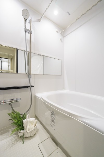 横長ミラーの効果で実際のサイズよりも広がりを感じるバスルームです。ホワイトを基調とした清潔感溢れる空間で、ゆったりとおくつろぎいただけます。