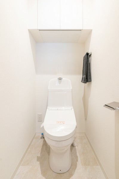 LIXIL製洗浄便座付トイレを新規設置。トイレットペーパーなどの収納に便利な吊戸棚も備え付けです。