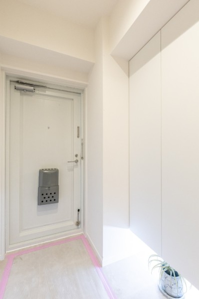 清潔感が溢れる白を基調とした玄関は、フットライトからのびる光が足元を優しく包み込む空間です。収納力の高いシューズボックスを造作しました。