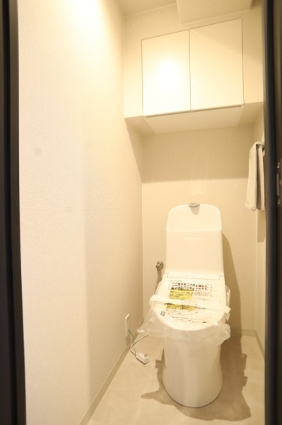 TOTO製ウォシュレット一体型のトイレ新規交換済みです。上部の吊戸棚にはペーパー類やお掃除用品などが収納でき、すっきりと清潔な空間を保つことが出来ます。