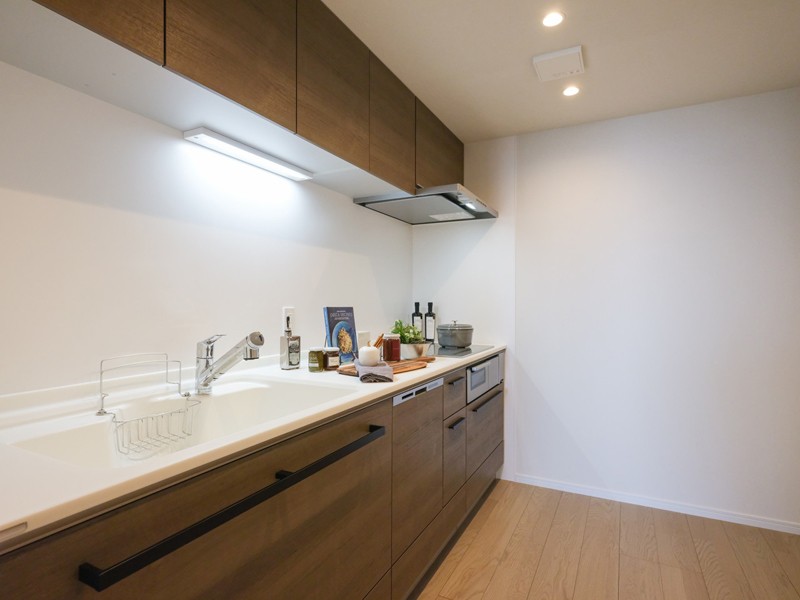 家事が捗りお手入れもしやすい壁付けのキッチンです(IHコンロ採用)。ゆとりある作業スペースや豊富な収納で実用的。木の温もりが漂うデザインを採用しました。