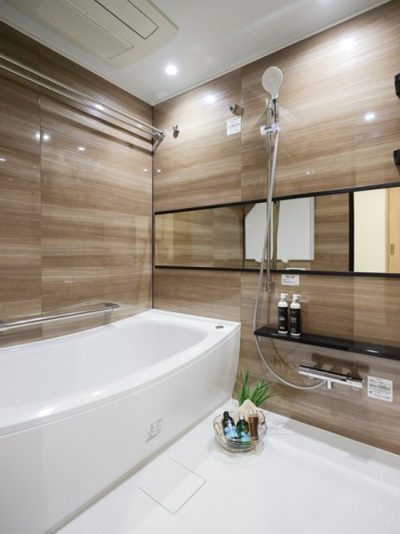 光沢感のある木目調パネルのバスルームです。ゆったりと体を伸ばせる1418サイズの浴室で、くつろぎのひとときをお過ごしいただけます。