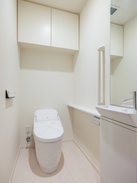 上部吊戸棚付きのレストルームにはスマートなタンクレストイレが設置されています。ホテルライクな手洗い場も備え付けです。