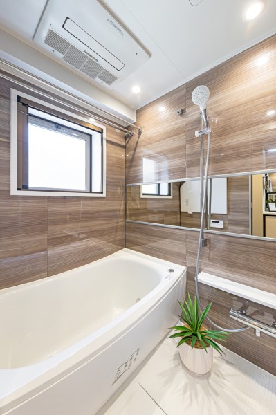 浴室にも窓があるので、自然光を採り込み換気にも嬉しいバスルームです。光沢のある木目調のパネルが、より一層くつろぎの空間へ誘います。