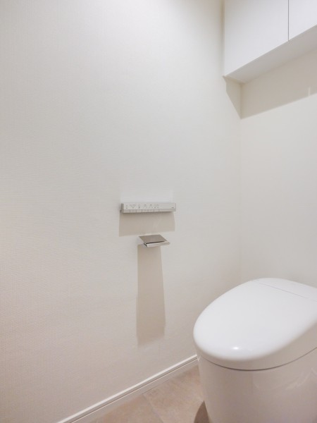便利な吊戸棚収納を備え付けた1階レストルームです。空間をすっきりと保つことができるスマートなタンクレストイレを新規設置しました。