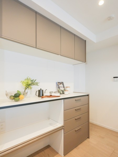 キッチン背面には統一したデザインのカップボードがあります。家電の配置や食器などの収納スペースが充実しています。