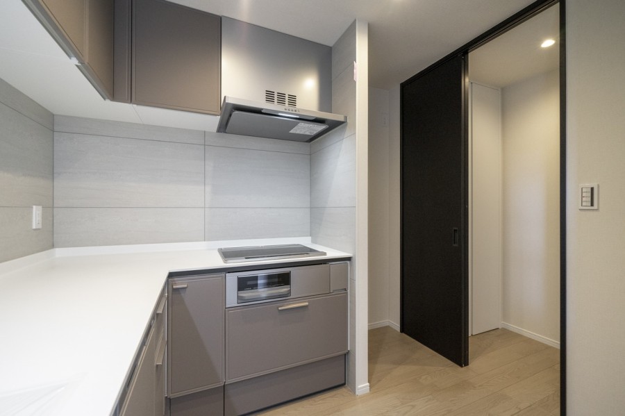 キッチンと廊下は引き戸で繋がっていて回遊性の高い住まいです。廊下にある収納棚も活用できますね。