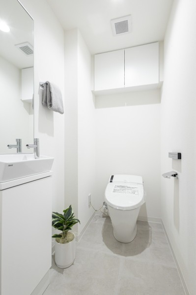 レストルームも上品さが宿る安らぎのスペース。スタイリッシュなタンクレストイレを設置し、大きな鏡と手洗い場を設けたことでちょっとした身だしなみチェックにも便利で実用的な空間です。