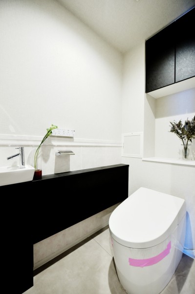 タンクレストイレに手洗いカンターつきのすっきりとした空間です。手洗いカンターはお客様も利用しやすいですね。吊戸棚もありますので、細々としたお手入用品などの収納にも便利です。
