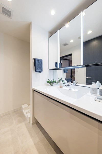 明るくライトアップされた洗面化粧台は大きな三面鏡やゆとりあるカウンタースペースなど、ラグジュアリーなプライベート空間を演出します。