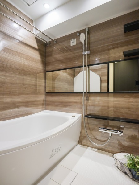 光沢のある木目調パネルが高級感を醸し出すゆったりとしたバスルームです。美しいカーブと全身を包み込むような入浴感が特長の浴槽です