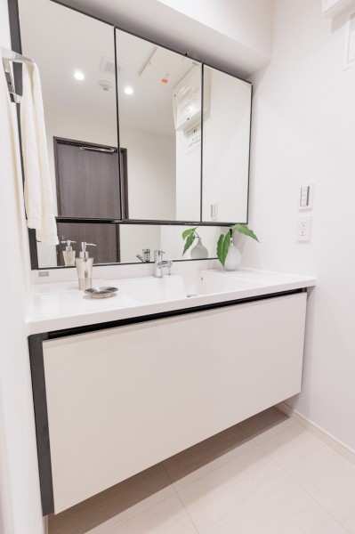 ゆとりのある洗面化粧台は大きな鏡が印象的なラグジュアリーな空間です。身だしなみチェックや鏡裏の収納が便利な三面鏡になっています