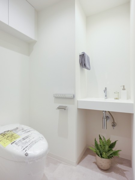 清潔感のあるレストルームには洗練されたお部屋にぴったりなスマートなタンクレストイレを採用。上部吊戸棚、手洗いカウンターなどの機能的な設備を備え付けました。