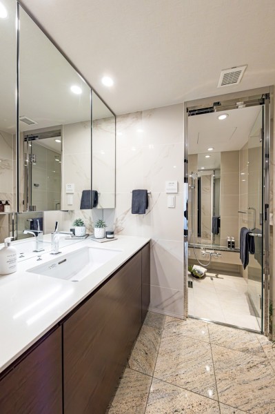 入浴後の豊かな時間を演出し、心からくつろげるプライベートスペースの洗面化粧室です。大きく構えられた三面鏡、乳白色の大理石調パネルが取り入れられたラグジュアリーな空間です。