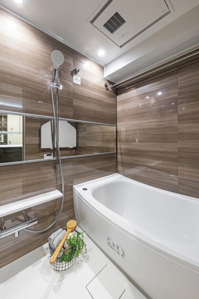 光沢のある木目調パネルが高級感を漂わせるバスルームです。美しいカーブと全身を包み込むような入浴感が特長の浴槽です。