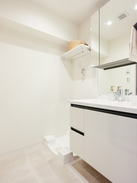 清潔感漂う洗面室です。三面鏡のミラーキャビネットに小物を収納でき、すっきりとした空間を保てますね。