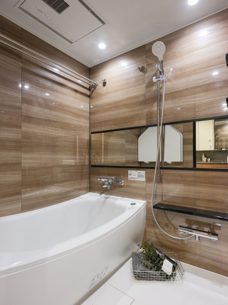 光沢のある木目調パネルがより一層の高級感を醸し出すバスルームです。美しいカーブと全身を包み込むような入浴感が特長の浴槽です。
