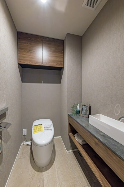 レストルームにはスマートなタンクレストイレを新規設置しました。手洗いカウンターや収納に便利な上部吊戸棚も備え付けです。