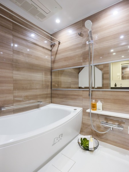 光沢のある木目調パネルが高級感を漂わせるバスルームです。ゆったりとしたバスタブで毎日のお風呂時間を心ゆくまで楽しめます。