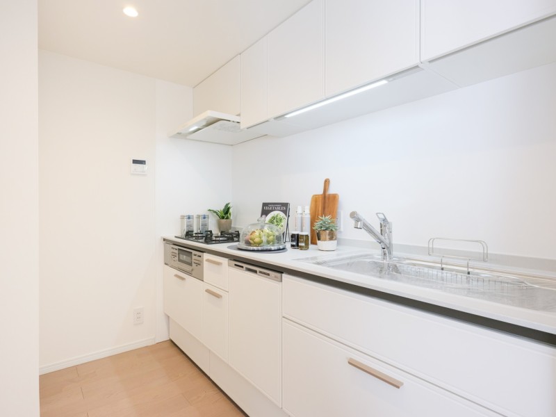 清潔感溢れるホワイト基調のキッチンは収納豊富な壁付けタイプ。家事時短に便利な食洗器を搭載、機能性もデザイン性も兼ね備えています。