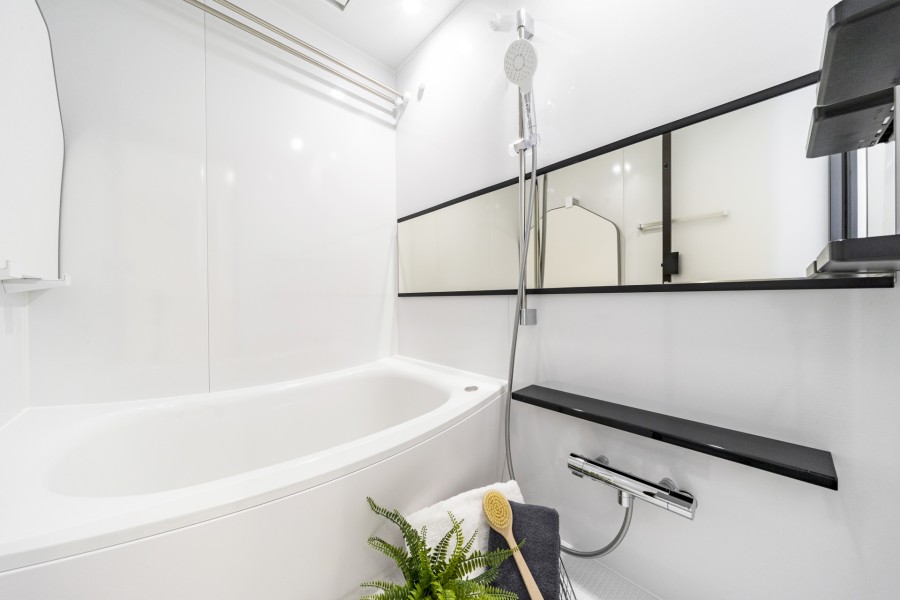 白を基調としたバスルームは、清潔感のある開放的な空間が広がります。美しいカーブと全身を包み込むような入浴感が特徴の浴槽です。