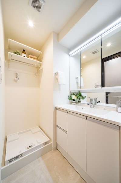 白を基調とした清潔感のある空間です。洗濯機置場の上には便利な棚を備え付けています。
