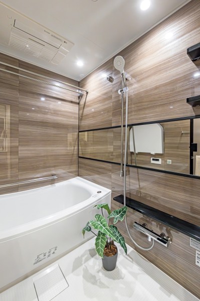 浴槽・洗い場共にゆとりのあるバスルームです。光沢のある木目調のパネルがより高級感を感じさせ、毎日のお風呂時間を心ゆくまで楽しめます。