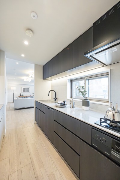 使いやすさとデザイン性を兼ね備えた田中工藝製のシステムキッチンです。木目調の面材が上質なお部屋に調和しています。